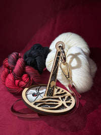 Wooden skein holder with colorful yarn on a red background