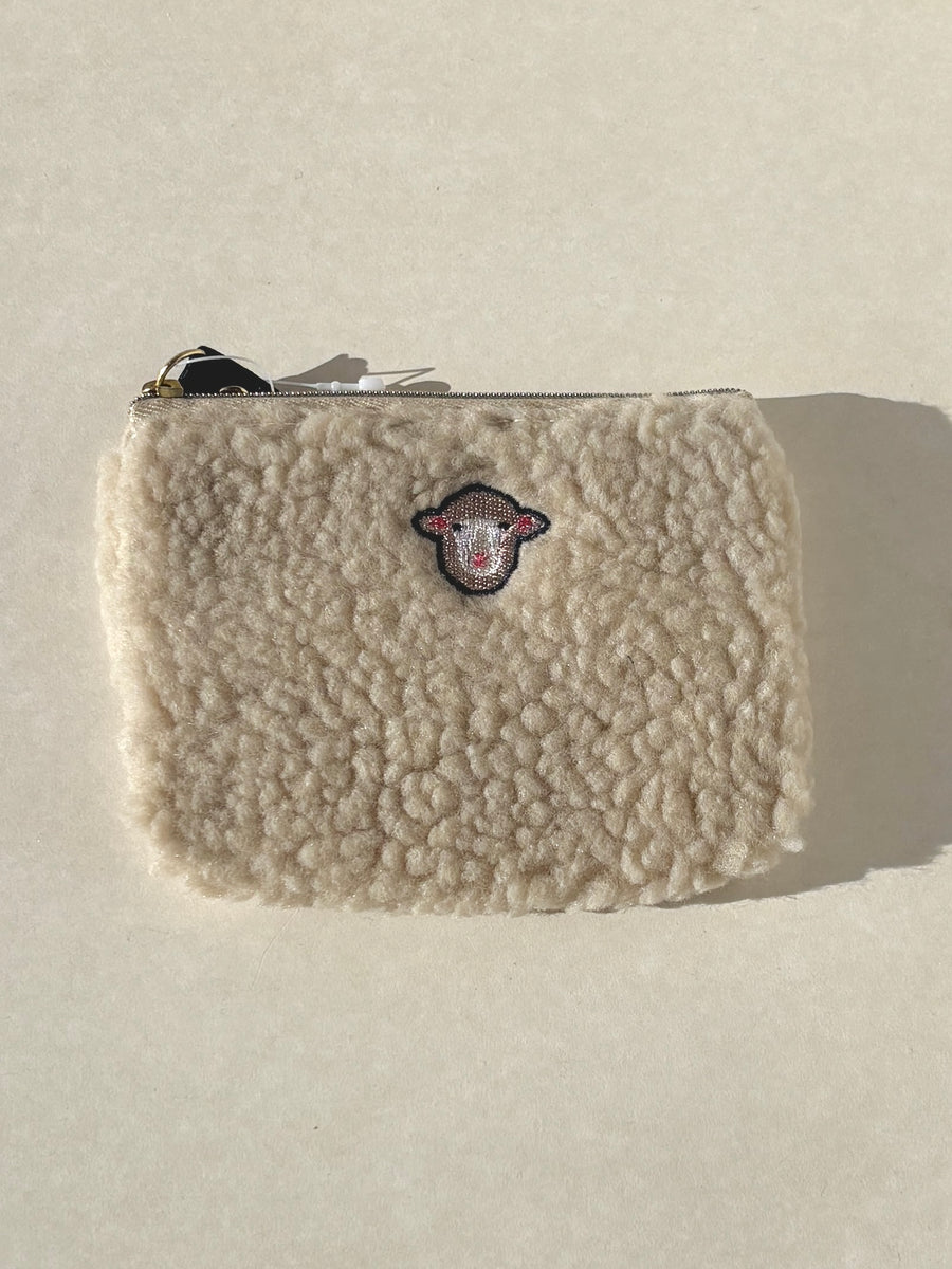 Beige sherpa pouch with a logo on a light gray background