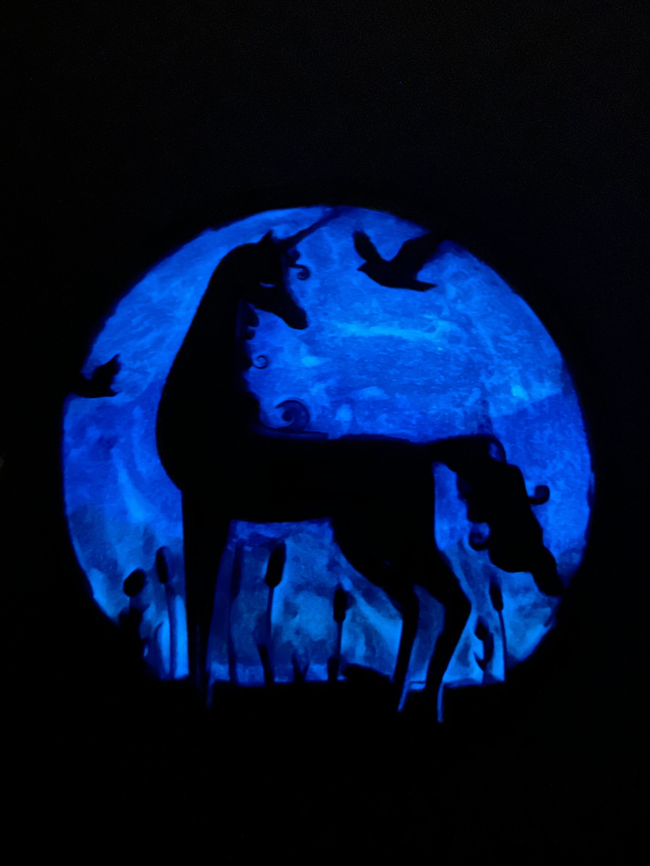 A yarn holder featuring a ghostly blue glow-in-the-dark background with the silhouette of a unicorn.