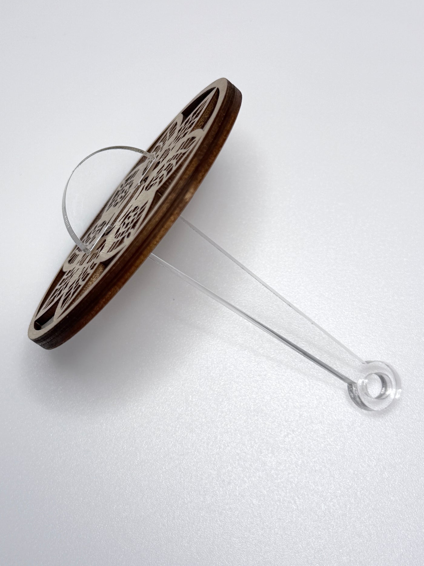 wooden yarn holder with a clear acrylic stick on a white background