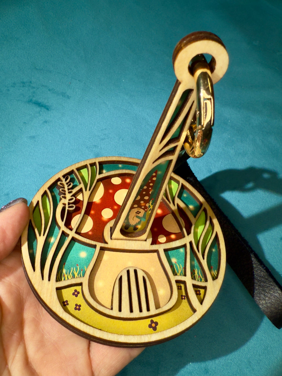 Decorative yarn holder with mushroom design held against a blue background
