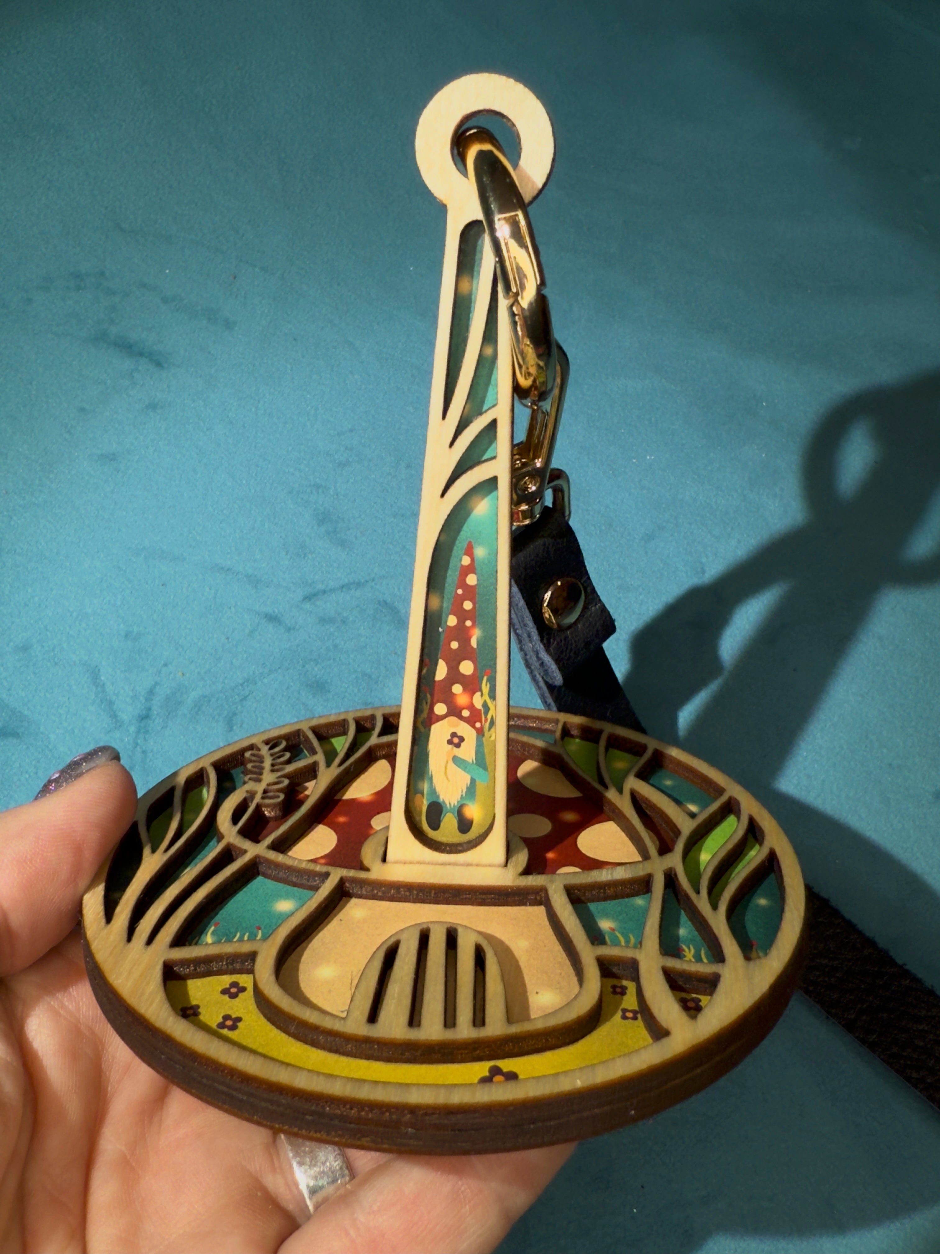 Portable wood yarn holder with a gnome and toadstool design on a blue background
